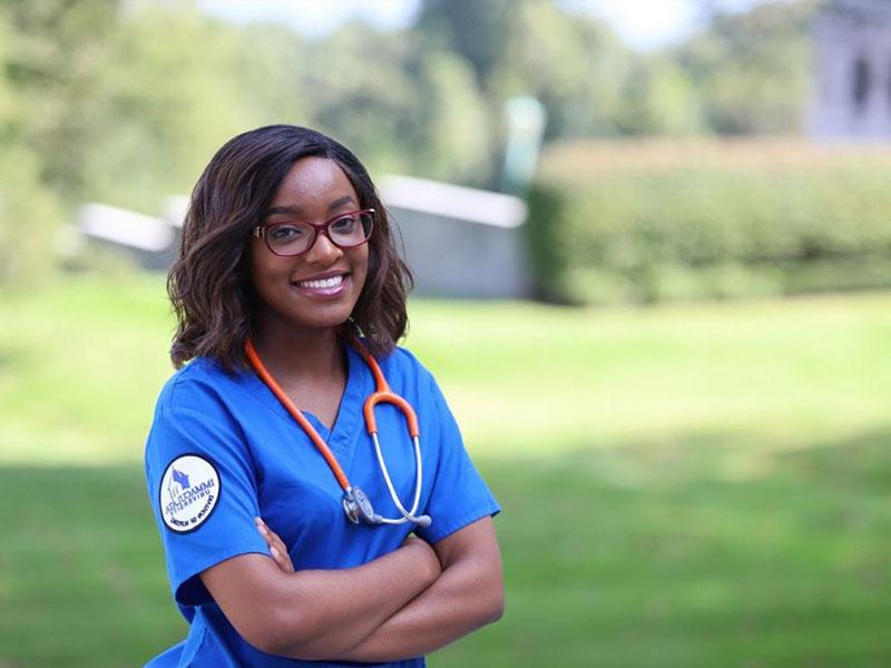 Woman with stethoscope, wearing blue scrubs